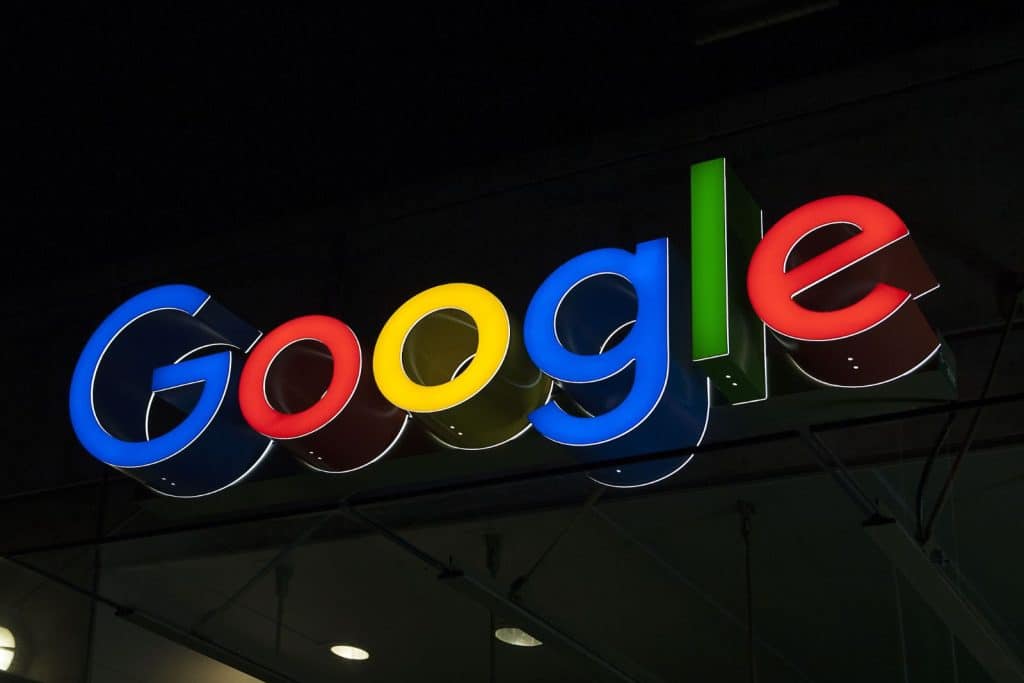 Illuminated Google logo sign with colorful letters against a dark background.