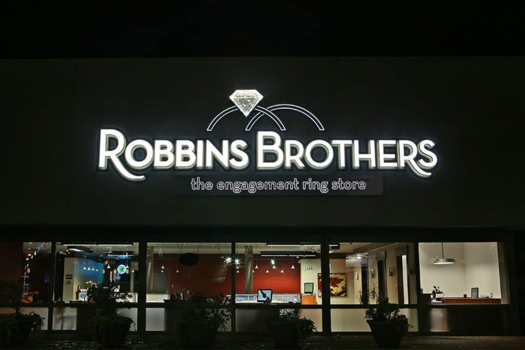 The image shows the illuminated storefront of Robbins Brothers, the engagement ring store, at night.