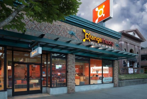 Exterior view of an Orangetheory Fitness location with brick facade and large windows.