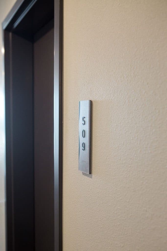 Room entrance with a wall-mounted silver plaque showing the number 509.