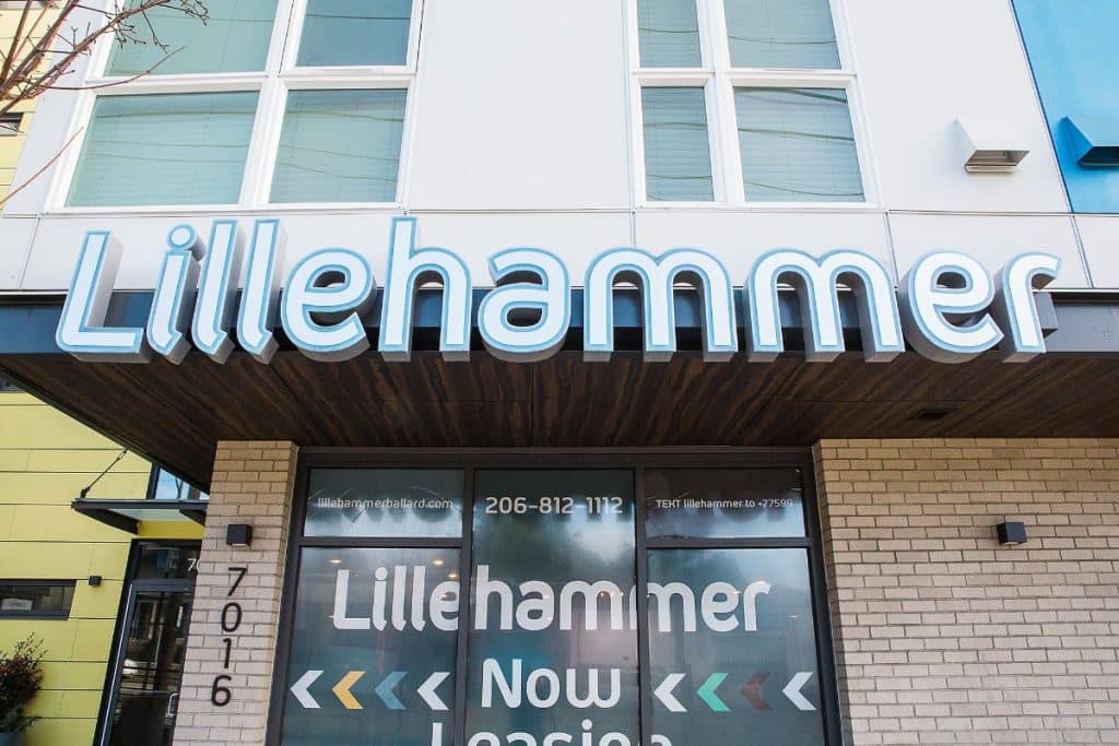 Sign for Lillehammer apartments with leasing information and a phone number. Building exterior visible.