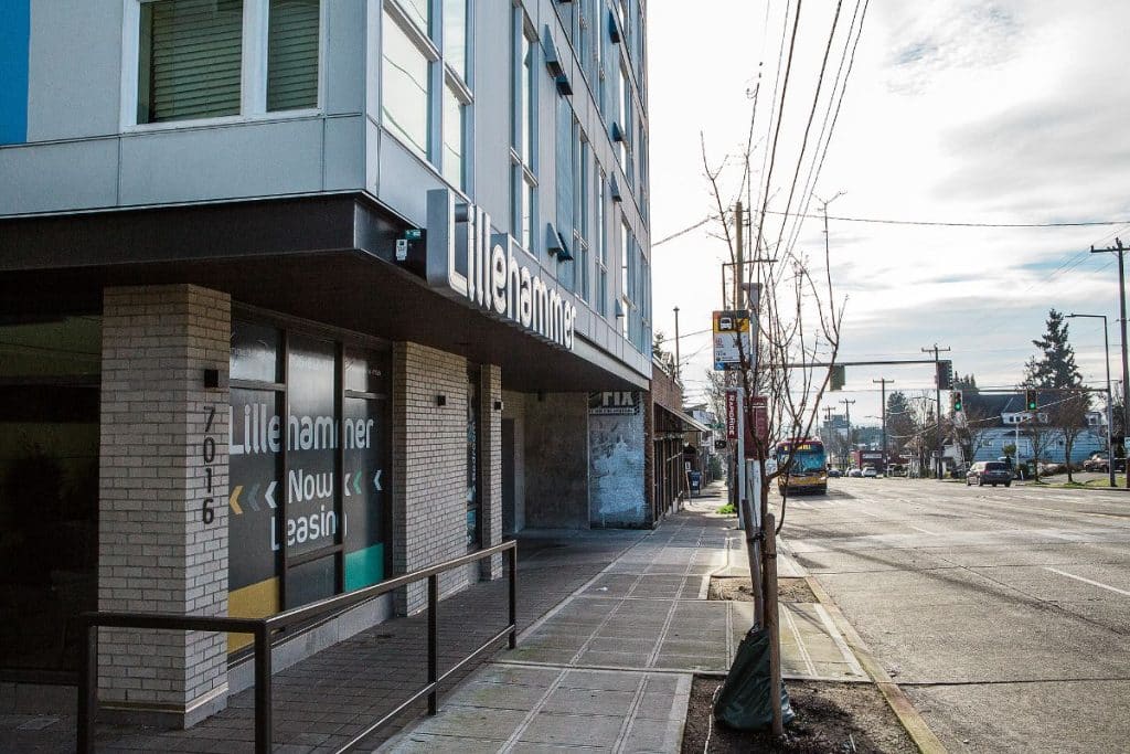 Street view of a building with "Lillehammer" signage, "Now Leasing" notice, and a bus stop.