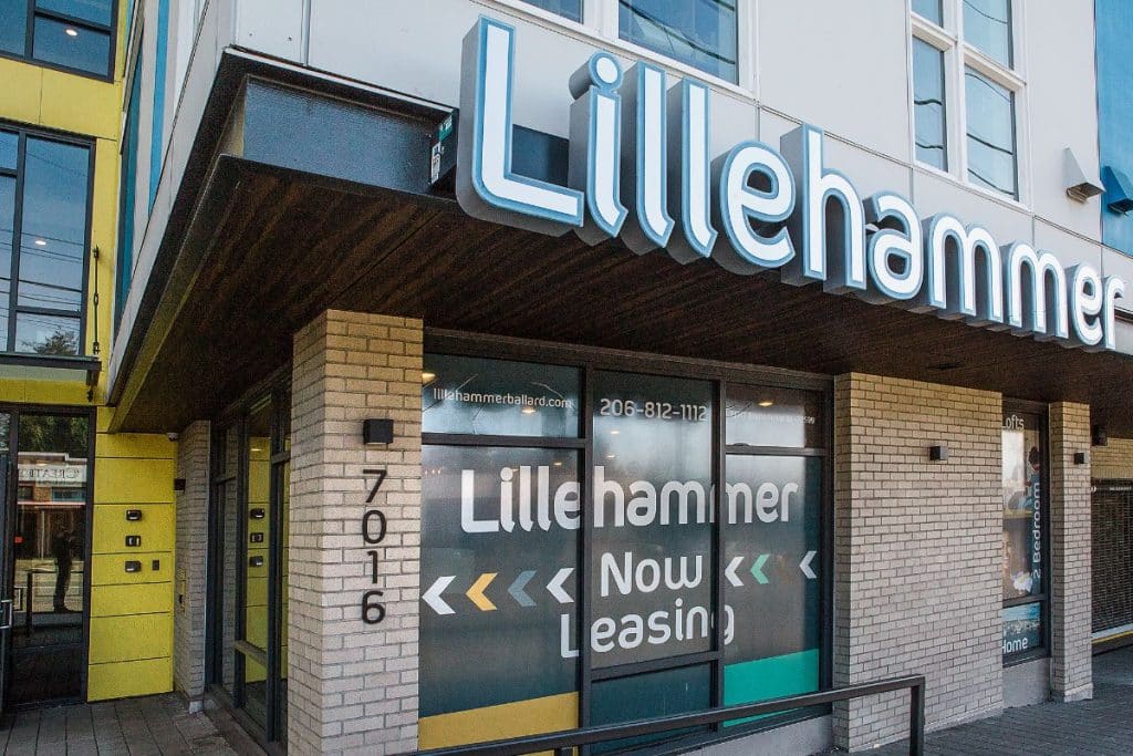 Storefront of Lillehammer building with "Now Leasing" sign and contact information on the window.