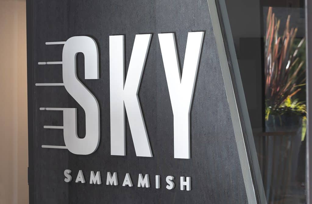 Sign reading "SKY SAMMAMISH" on a dark wall background.