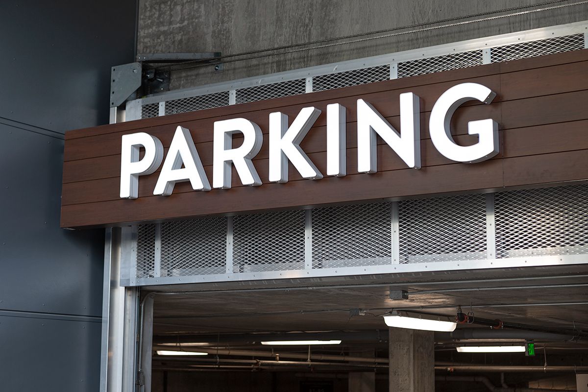 Illuminated parking sign above the entrance to a parking garage.