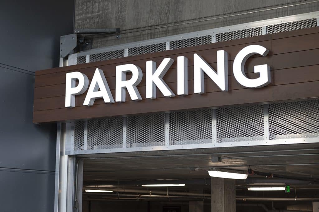 Sign reading "PARKING" mounted above the entrance to a parking garage.