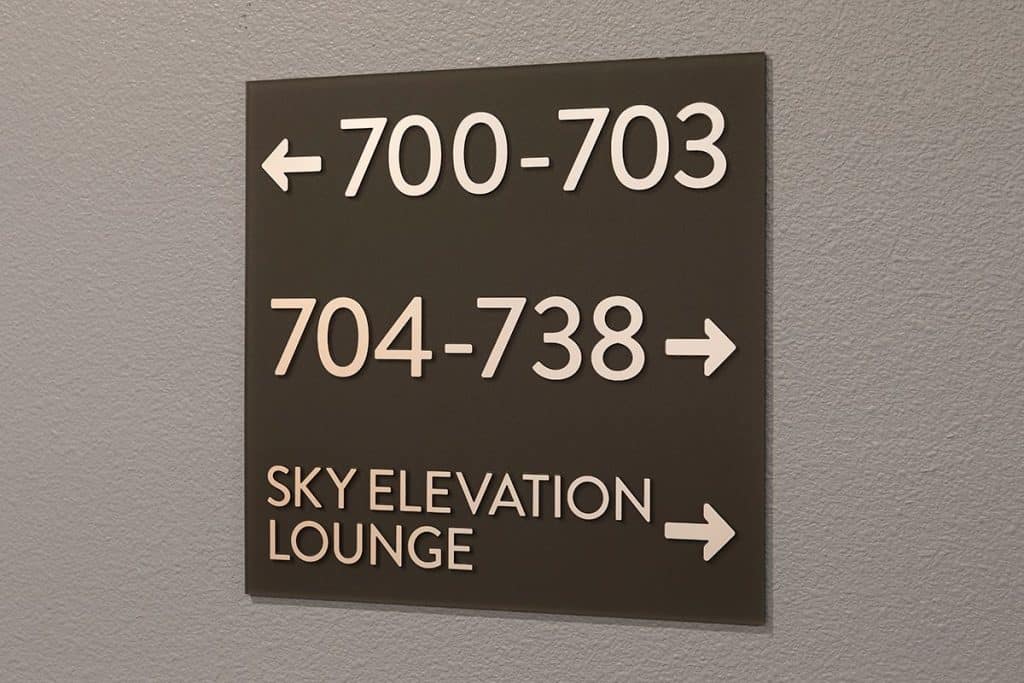 Directional sign with arrows: Rooms 700-703 to the left, rooms 704-738 to the right, Sky Elevation Lounge to the right.