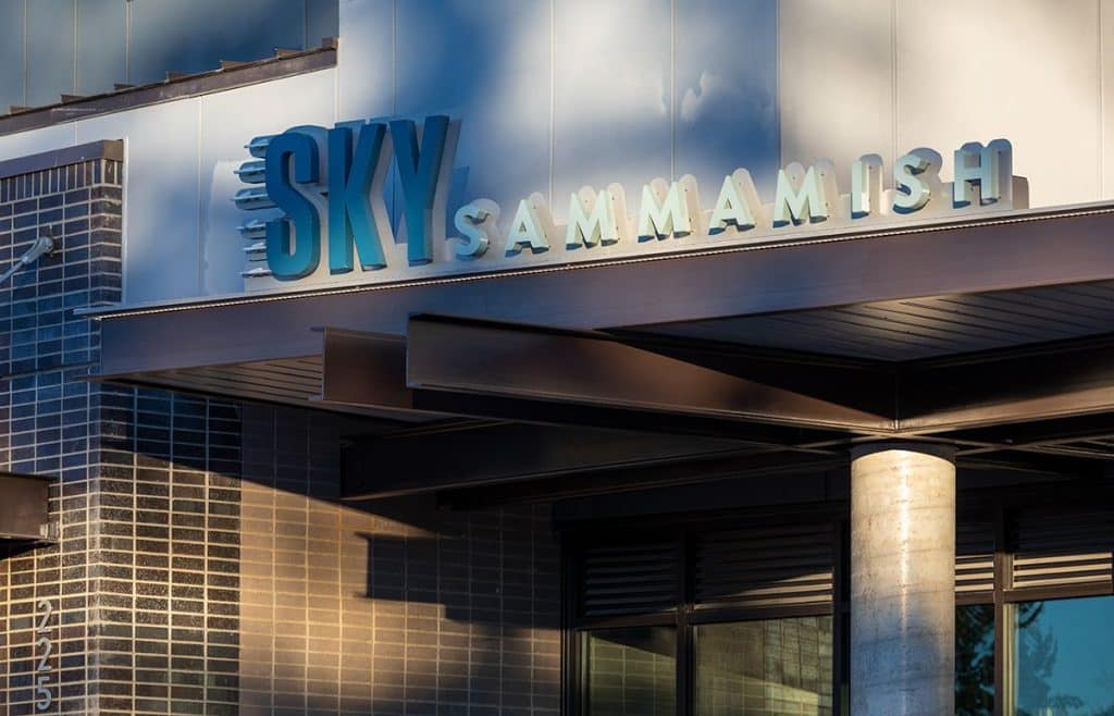 Sign reading "Sky Sammamish" on a modern building facade with brick and metal elements.