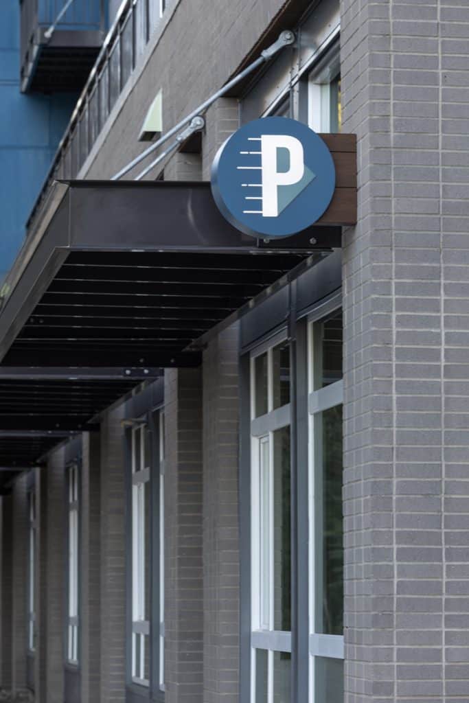 Building exterior with a "P" logo sign mounted above windows, indicating parking.