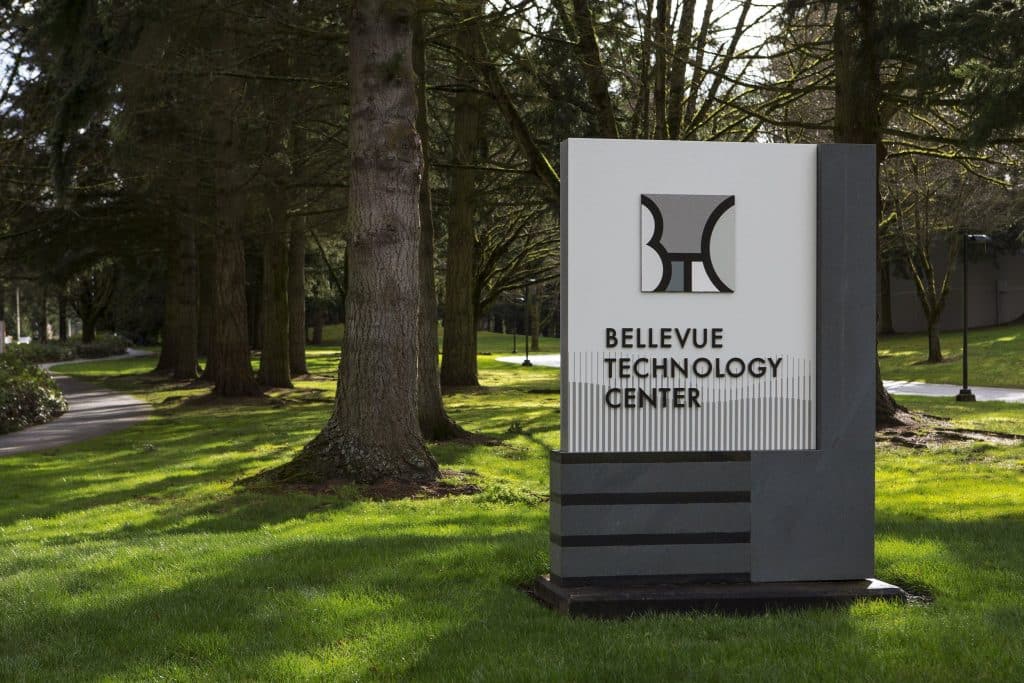 Sign for Bellevue Technology Center surrounded by grass and trees.