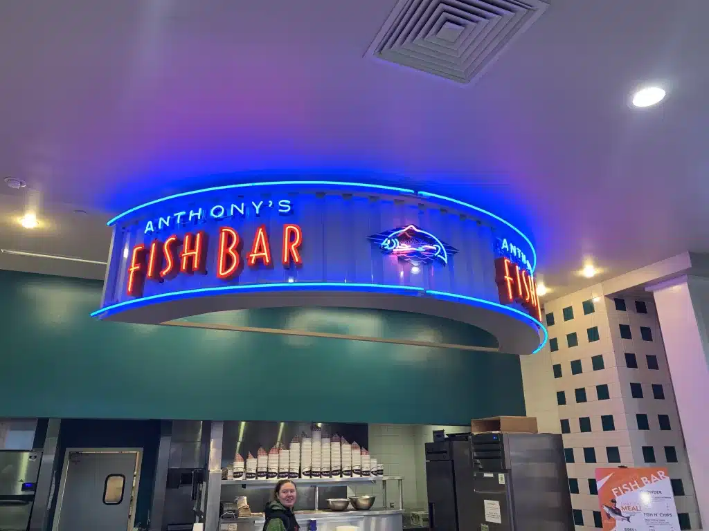 Anthony's Fish Bar neon sign with blue lights and a fish logo inside a restaurant.