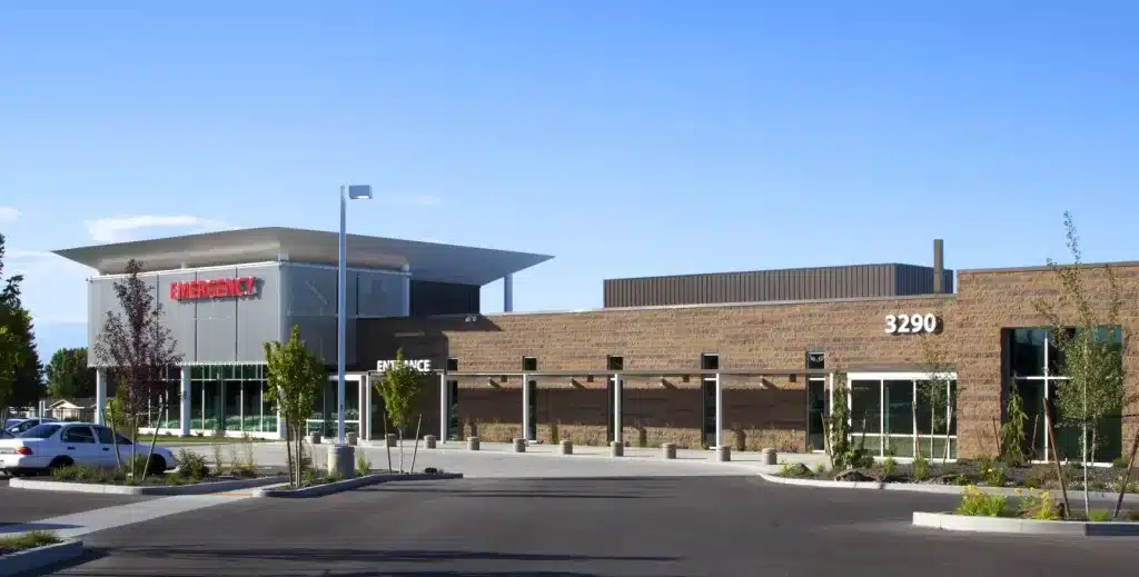 Modern emergency facility with a flat-roof design, clear blue sky, and surrounding trees. Building number 3290 is visible on the front.