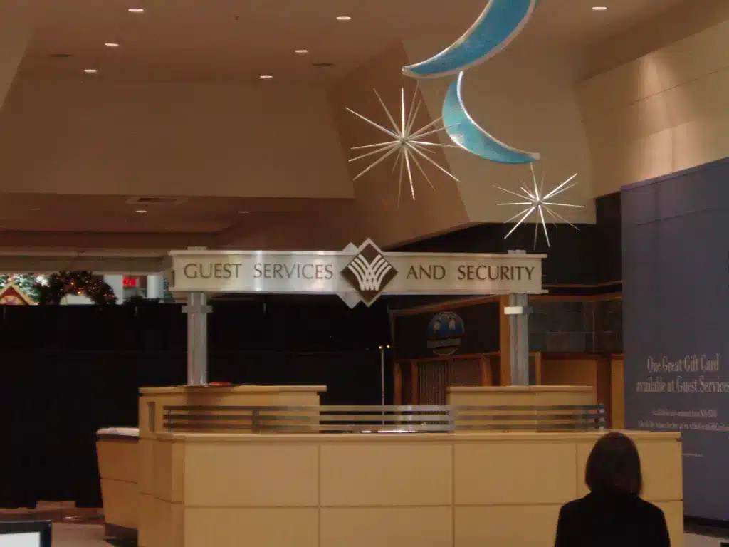 Guest services and security desk in a shopping mall, with decorative stars and moon above.