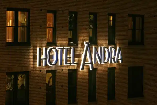 Illuminated "Hotel Ändra" sign on a brick building facade at night.