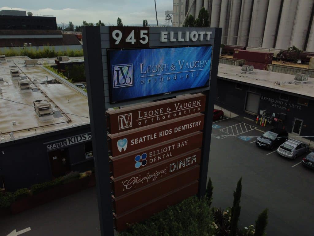 Sign displaying business names: Leone & Vaughn Orthodontics, Seattle Kids Dentistry, Elliott Bay Dental, and Charleys' Diner, located at 945 Elliott.